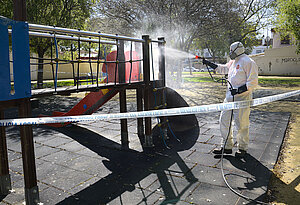 Un trabajador desinfectando un parque infantil